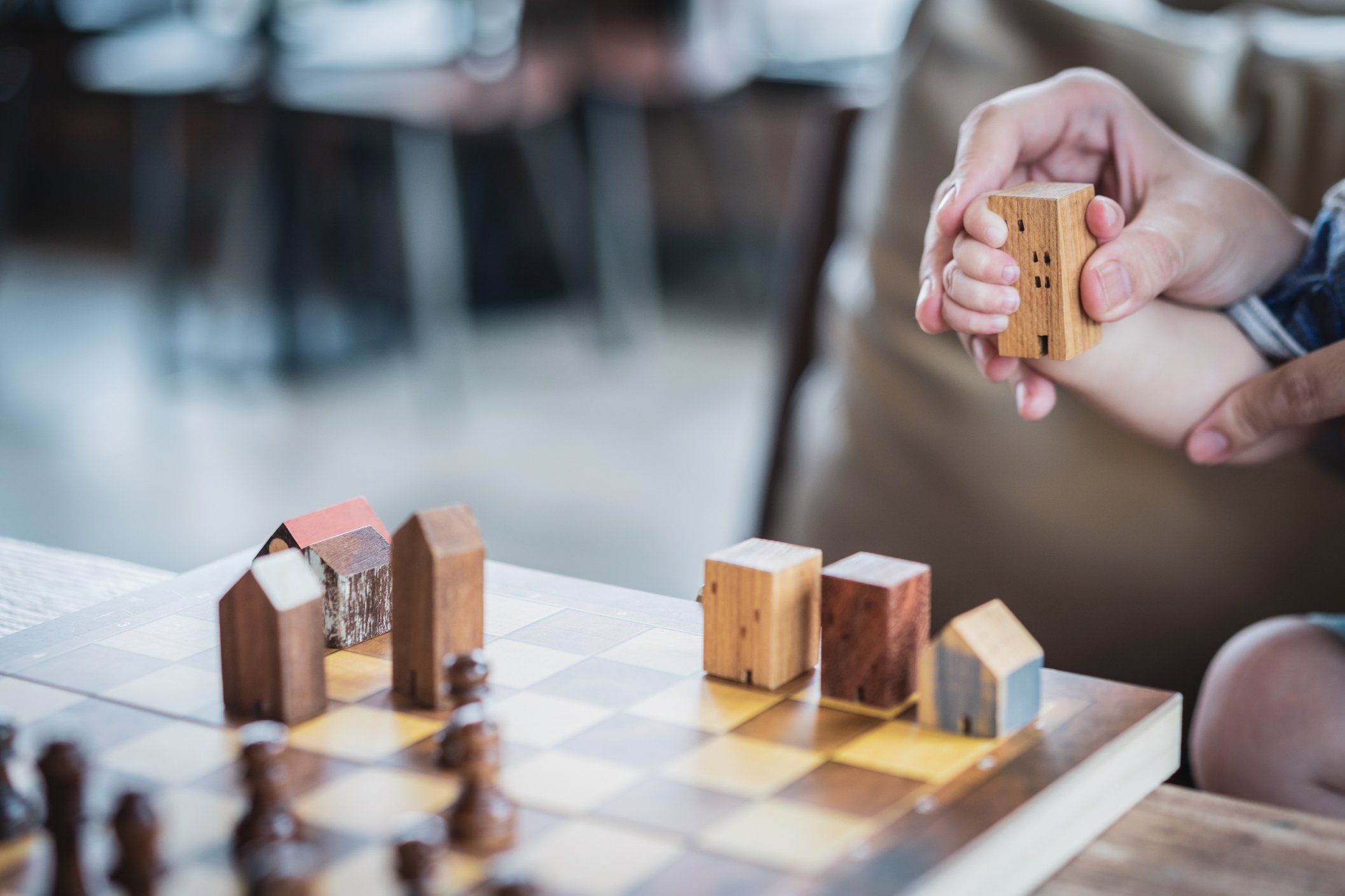 Baby Hands holding a house model with mother hand. The concept of relocation, mortgage, inheritance, family assurance protection and legacy planning.